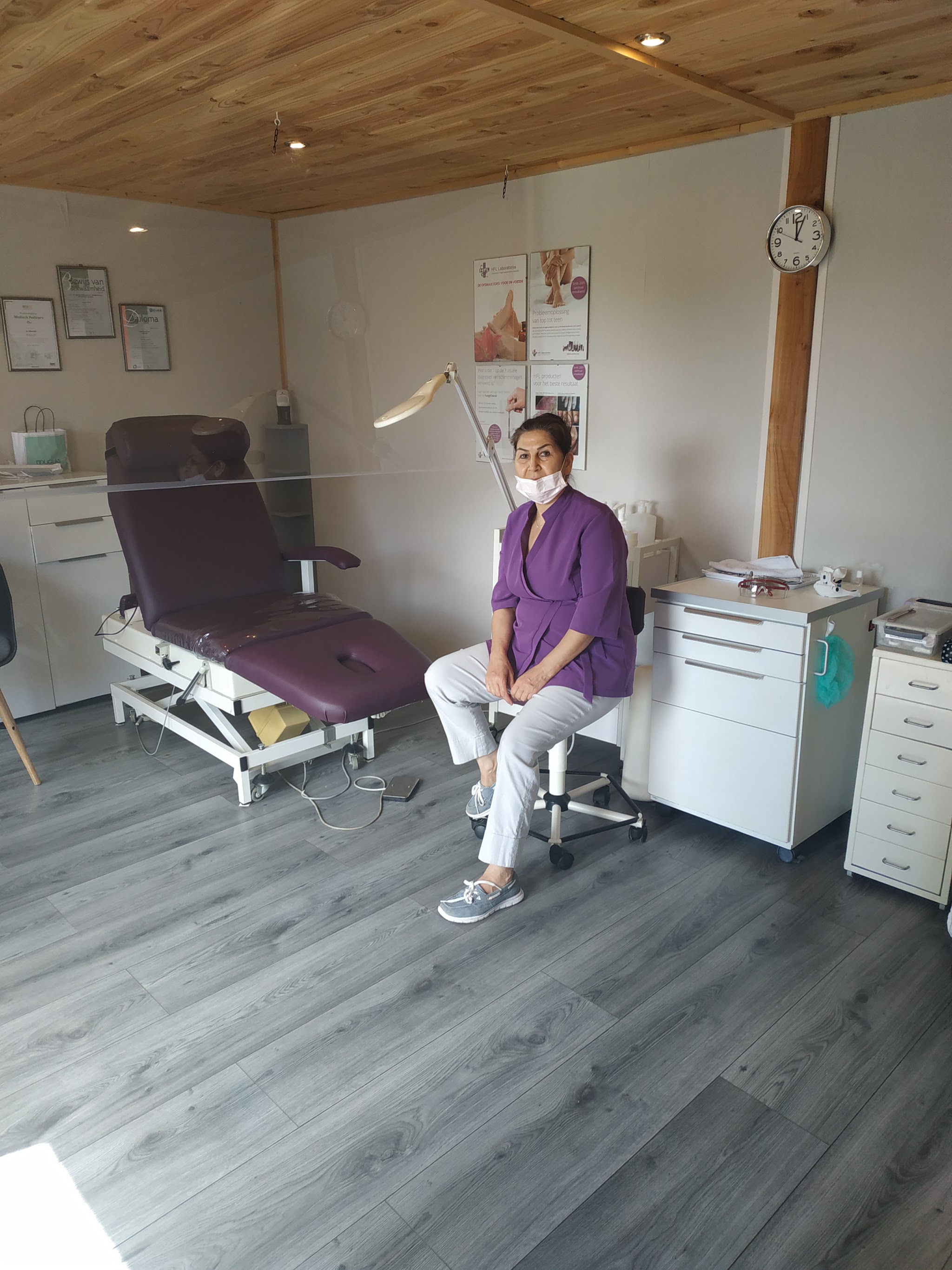 Aki Ghasemi in een lila tuniek in haar behandelkamer