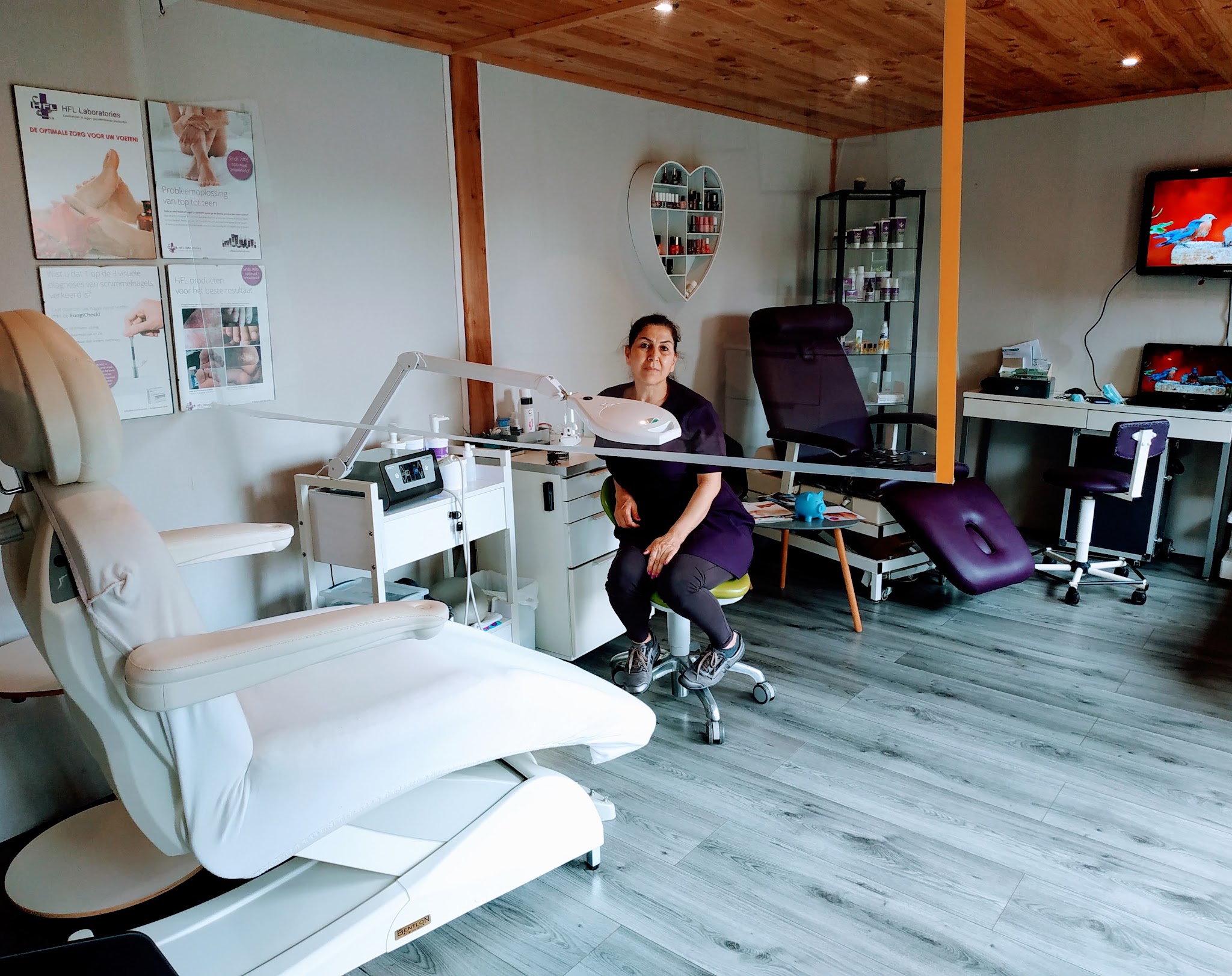 De behandelkamer met de witte elektrische pedicurestoel en een lamp met vergrootglas